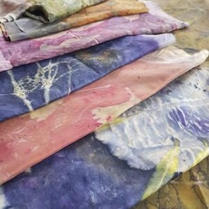 Peut inclure: Six carr&eacute;s de tissu empil&eacute;s dans diff&eacute;rentes nuances de bleu, rose, violet et jaune. Le tissu a un aspect naturel et organique avec un motif subtil.