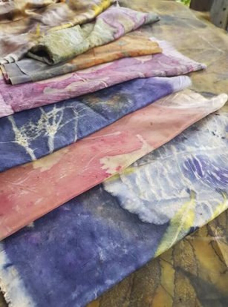 Peut inclure: Six carr&eacute;s de tissu empil&eacute;s dans diff&eacute;rentes nuances de bleu, rose, violet et jaune. Le tissu a un aspect naturel et organique avec un motif subtil.