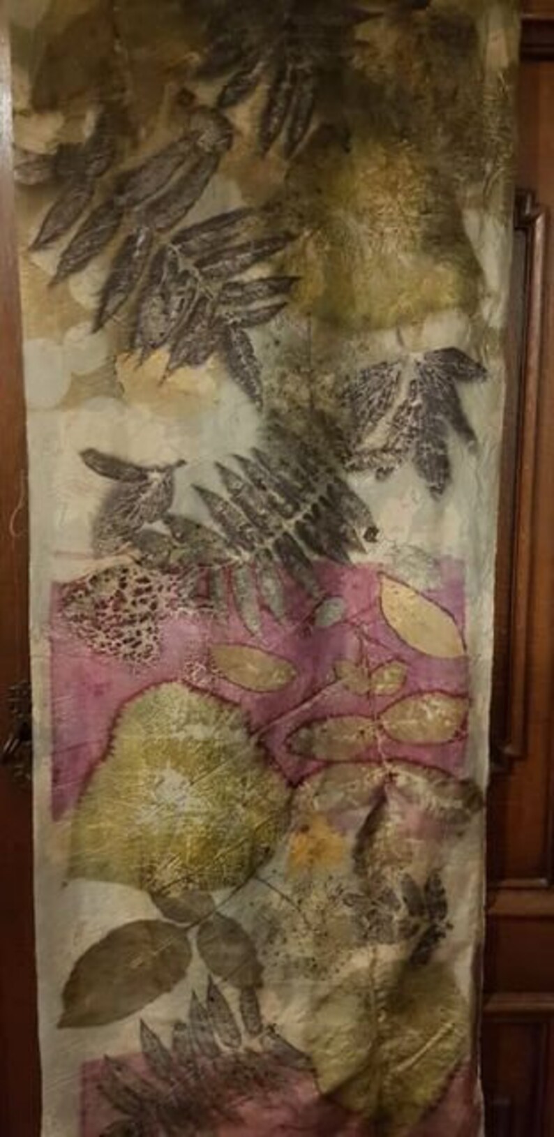Peut inclure: Une &eacute;charpe en soie blanche avec un imprim&eacute; botanique repr&eacute;sentant des feuilles et des fleurs dans des tons de vert, marron et rose.
