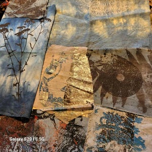 Op de afbeelding: Een assortiment van textielstukken met verschillende ontwerpen. Sommige stoffen hebben botanische prints, tie-dye effecten en bladgoud accenten. Andere stoffen hebben cirkelvormige patronen en sierlijke blauw-witte bloemmotieven.