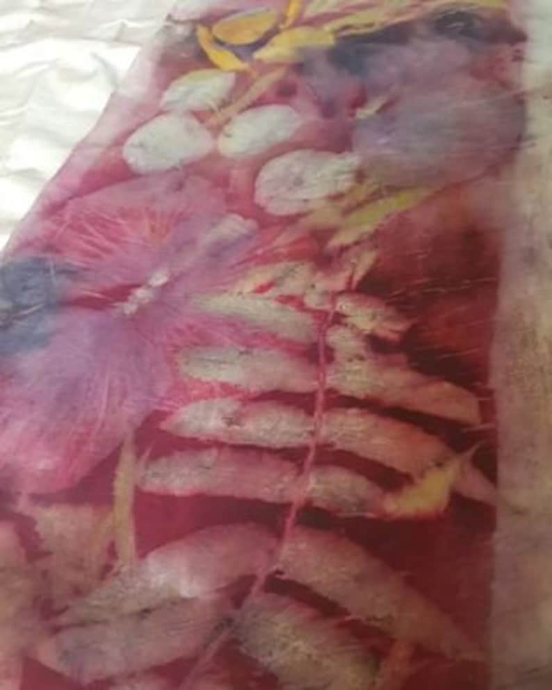 Peut inclure: Un gros plan sur un tissu avec un imprim&eacute; botanique. Le tissu est de couleur rouge fonc&eacute; avec un motif de feuille de foug&egrave;re dans une nuance plus claire de rouge et de blanc. L'arri&egrave;re-plan est de couleur cr&egrave;me clair.