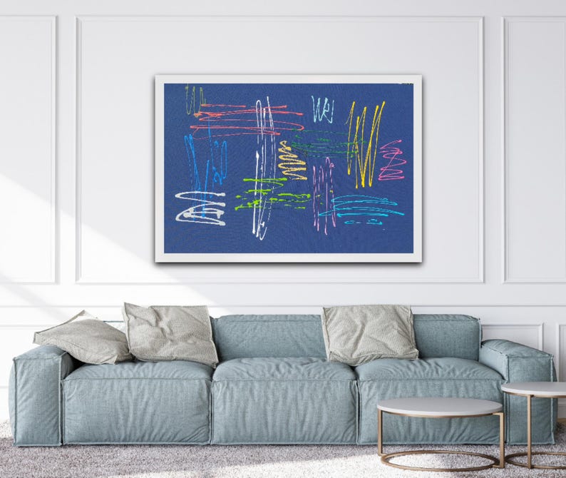 K&ouml;nnte beinhalten: Abstrakter Kunstdruck mit bunten Linien und Kritzeleien auf dunkelblauem Hintergrund. Der Druck ist in einem wei&szlig;en Rahmen gerahmt und h&auml;ngt an einer wei&szlig;en Wand &uuml;ber einem blauen Sofa.