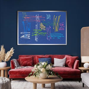 K&ouml;nnte beinhalten: Ein gerahmter abstrakter Kunstdruck mit bunten Linien und Formen auf blauem Hintergrund. Der Druck h&auml;ngt an einer dunkelblauen Wand &uuml;ber einem roten Samtsofa.