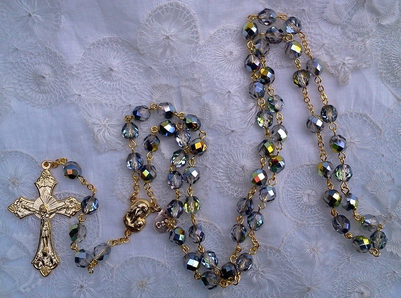 May include: A gold rosary with a gold crucifix and blue iridescent glass beads.