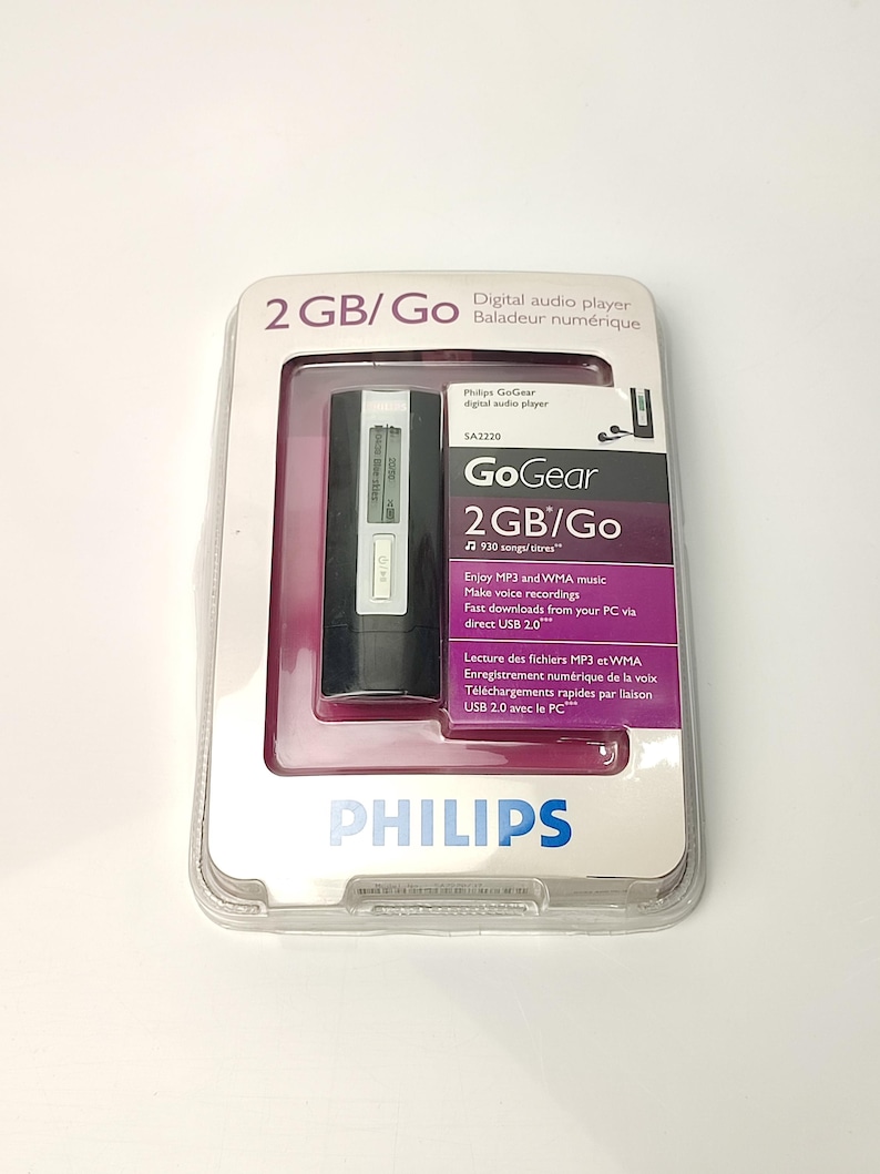 Pu&ograve; includere: Un lettore audio digitale Philips GoGear 2GB/Go nella sua confezione originale. Il lettore &egrave; nero e argento, con il testo "GoGear" e "2GB/Go" visibili. La confezione include testo in inglese e francese.