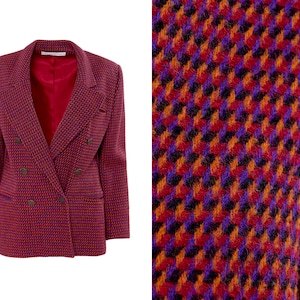 May include: A double-breasted blazer in a red, orange, and purple houndstooth pattern. The blazer has a notched collar and long sleeves.