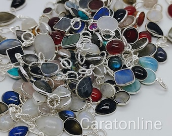 Puede incluir: Un montón grande de dijes colgantes de plata con varios colores de piedras preciosas, incluyendo azul, verde, rojo y blanco. Los dijes tienen forma de lágrima, óvalo y cuadrado. El texto "Caratonline" es visible en la esquina inferior derecha de la imagen.