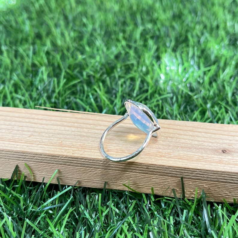 Puede incluir: Un anillo de plata con una gran piedra de &oacute;palo de forma ovalada. El &oacute;palo es iridiscente y tiene un color blanco lechoso.