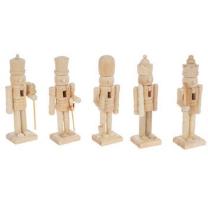 May include: Five unfinished wooden nutcracker figurines in various poses. Each figure is light-colored, with a classic nutcracker design, including hats, uniforms, and rectangular bases. The figures are standing in a row against a white background.