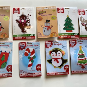 May include: A set of ten Christmas craft kits featuring foam and felt ornaments. The kits include a penguin, snowman, gingerbread man, stocking, candy cane, tree, and reindeer. Each kit includes pre-cut foam or felt pieces, instructions, and embellishments.