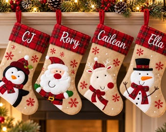 Pode incluir: Quatro meias de Natal beges com punhos de xadrez vermelho, personalizadas com os nomes CJ, Rory, Cailean e Ella. As meias apresentam flocos de neve vermelhos bordados e personagens aplicados: um pinguim, Pai Natal, uma rena e um boneco de neve.