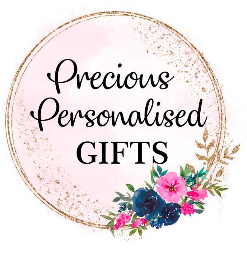 May include: A logo featuring the text "Precious Personalised GIFTS" in a black script font, set within a gold-lined circle with a pink watercolor background. A floral arrangement of pink and blue flowers adorns the bottom right.
