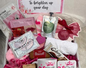 Pode incluir: Uma caixa de presente com uma caneca e porta-copos 21 & Fabulous, uma barra de chocolate Galaxy, um biscoito Biscoff, um elástico de cabelo rosa, uma máscara facial, adesivos para olhos, uma bolsa verde, uma bomba de banho e um cartão A Special Gift.