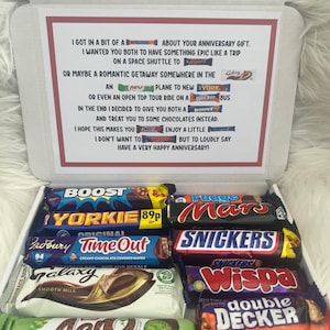 May include: A white gift box filled with a selection of chocolate bars such as Boost, Yorkie, Time Out, Galaxy, Aero, Mars, Snickers, Wispa, and Double Decker. The box has a printed anniversary message.