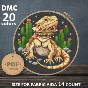 Pode incluir: Padrão de ponto cruz de um dragão barbudo com cactos em fundo preto, num bastidor de madeira. O texto da imagem diz "DMC 20 cores" e "PDF Pattern". Tamanho final: 18,14 x 18,87 cm.