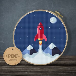 May include: A red rocket ship with a white flame blasts off from a snowy mountain range against a dark blue night sky with white stars and a white moon.
