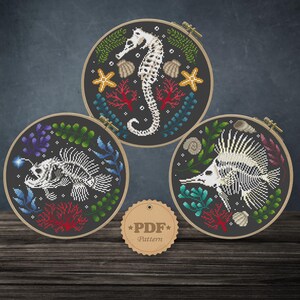 Könnte beinhalten: Drei Stickmuster mit skelettartigen Meeresbewohnern auf dunklem Hintergrund. Die Muster umfassen ein Seepferdchen, einen Fisch mit langer Flosse und einen Fisch mit einem leuchtenden Köder. Die Muster sind mit "PDF Pattern" gekennzeichnet.