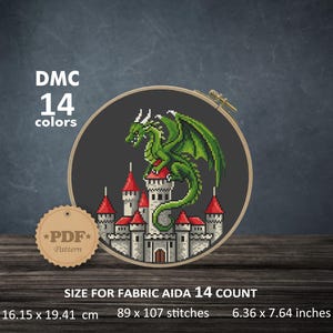 May include: Cross-stitch design of a green dragon perched atop a castle with red roofs, set against a dark gray background. The design is in a wooden embroidery hoop. The text reads "DMC 14 colors" and "PDF Pattern". The fabric size is 6.36 x 7.64 inches.