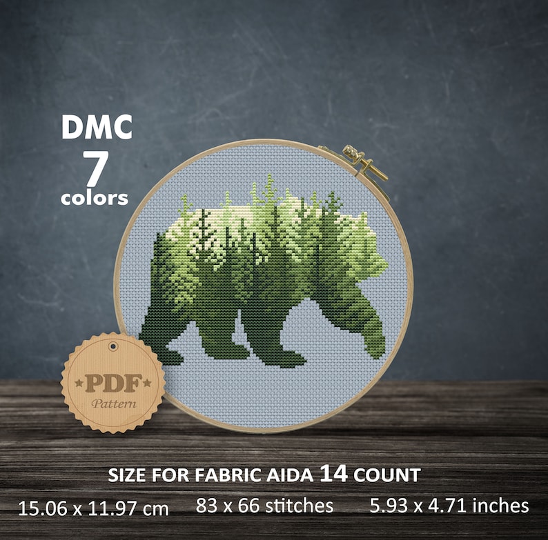May include: Cross stitch pattern of a bear silhouette with a forest inside. The pattern is for Aida 14 count fabric and measures 83 x 66 stitches, or 5.93 x 4.71 inches. The pattern requires 7 DMC colors.
