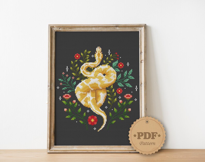 Op de afbeelding: Borduurpatroon met een gele slang met rode en groene bloemmotieven op een zwarte achtergrond. Het patroon is gemarkeerd met "PDF-patroon".