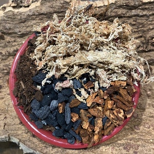 May include: A red ceramic pot filled with a mixture of brown soil, black charcoal, brown wood chips, and light brown sphagnum moss.
