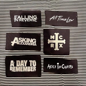 May include: Six rectangular black fabric patches featuring white printed band logos and text. The designs include Falling in Reverse, All Time Low, Asking Alexandria, a cross symbol with MCRX, A Day to Remember, and Alice in Chains.