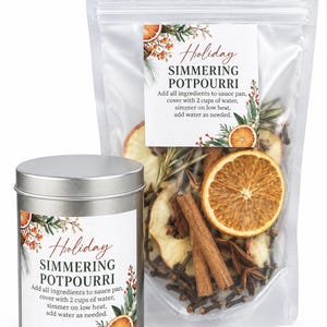 May include: A silver metal tin and a clear plastic pouch containing dried orange slices, cinnamon sticks, and cloves. Both feature labels reading: Holiday SIMMERING POTPOURRI. Add all ingredients to sauce pan, cover with 2 cups of water, simmer on low heat, add water as needed.