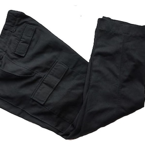 May include: Black cargo trousers with multiple pockets and a classic design. The trousers are made of a durable fabric and feature a straight leg cut. Suitable for casual wear.