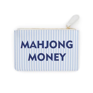 May include: A rectangular, zippered pouch with a white and light blue striped pattern. The words "MAHJONG MONEY" are printed in bold, dark blue letters across the front. The zipper pull is white.