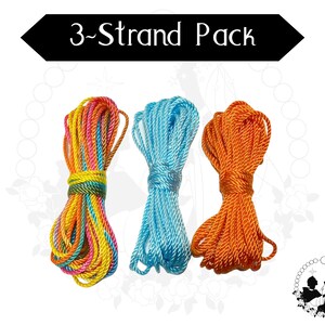May include: Three bundles of colourful rope are displayed against a white background. The ropes are in shades of rainbow, light blue, and orange. The text "3-Strand Pack" is in a black banner above the ropes.