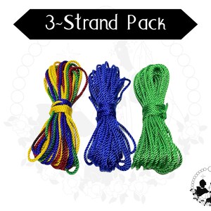 May include: Three bundles of rope in red, yellow, blue, and green. The text "3-Strand Pack" is displayed in a black banner above the ropes. The ropes are tightly wound and ready for use.
