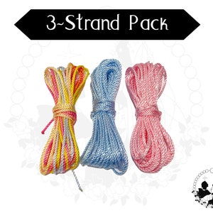 May include: Three bundles of rope in different colours are displayed. One is a mix of yellow, pink, and white. The second is light blue, and the third is pink. The text "3-Strand Pack" is above the ropes.