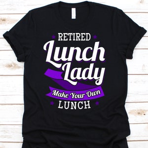 May include: Black t-shirt with the text "Retired Lunch Lady Make Your Own Lunch" in white and purple. The design includes a purple banner and star accents, perfect for a retired lunch lady.
