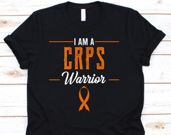 May include: Black t-shirt with the text "I AM A CRPS Warrior" in orange and white. An orange ribbon graphic is below the text. The shirt is a crew neck style.