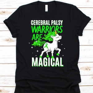 May include: Black t-shirt with a graphic of a white unicorn with green hair and a green ribbon. The text reads "CEREBRAL PALSY WARRIORS ARE MAGICAL" in green and white.