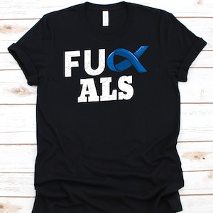 May include: Black t-shirt with the text "F*CK ALS" in distressed white lettering. A blue awareness ribbon is incorporated into the design. The shirt is made of a soft material.