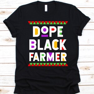 May include: Black t-shirt with the text "DOPE BLACK FARMER" in colorful block letters. The design includes red, green, and yellow geometric patterns at the top and bottom of the text.