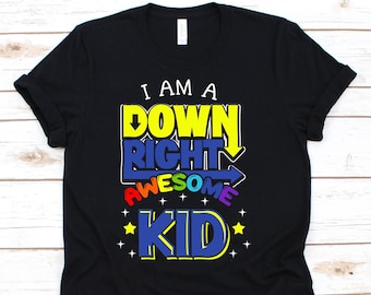 May include: Black t-shirt with the text "I AM A DOWN RIGHT AWESOME KID" in yellow, blue, and rainbow colors. The design includes arrows and stars, creating a vibrant and playful look. A casual tee for kids.