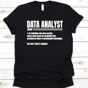 May include: Black t-shirt with the white text "DATA ANALYST" above a definition. The definition reads: "1. An individual who does precise guess-work based on unreliable data provided by those of questionable knowledge. See also: wizard, magician."