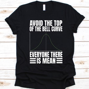 May include: Black t-shirt with white text and a green bell curve graphic. The text reads "AVOID THE TOP OF THE BELL CURVE EVERYONE THERE IS MEAN". The shirt is a casual wear item.