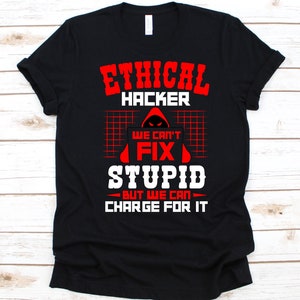 Może przedstawiać: Czarna koszulka z napisem "ETHICAL HACKER" w czerwonych, blokowych literach. Poniżej, grafika postaci w kapturze jest wyśrodkowana nad tekstem "WE CAN'T FIX STUPID BUT WE CAN CHARGE FOR IT" w kolorze białym.