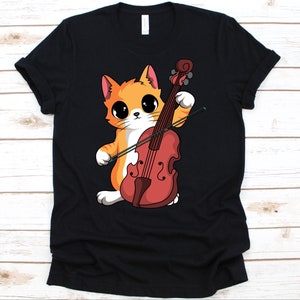 Puede incluir: Camiseta negra con un gato de dibujos animados tocando el violín. El gato es naranja y blanco con ojos grandes. El violín es de color marrón rojizo. El diseño está centrado en la camiseta.