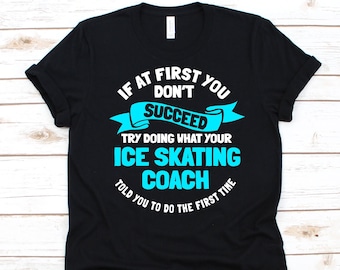 May include: Black t-shirt with the text "IF AT FIRST YOU DON'T SUCCEED TRY DOING WHAT YOUR ICE SKATING COACH TOLD YOU TO DO THE FIRST TIME" in white and turquoise. The shirt is a casual wear item.