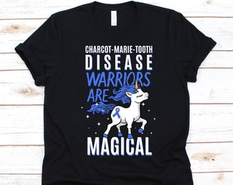 Può includere: T-shirt nero con una grafica di unicorno bianco e la scritta "CHARCOT-MARIE-TOOTH DISEASE WARRIORS ARE MAGICAL" in blu e bianco. L'unicorno ha criniera, coda e nastro blu.