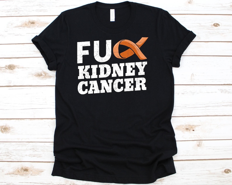May include: Black t-shirt with the text "FUCK KIDNEY CANCER" in white, with an orange awareness ribbon incorporated into the design. The shirt is made of a soft material and has a classic crew neck.