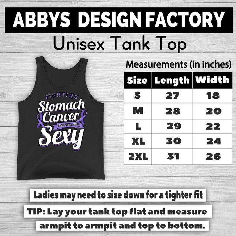 Op de afbeelding: Zwart unisex tanktop met de tekst "FIGHTING Stomach Cancer AND STILL THIS Sexy" in wit en paars. Afmetingen in centimeters, van S (68,5 cm lang, 45,7 cm breed) tot 2XL (78,7 cm lang, 66 cm breed).