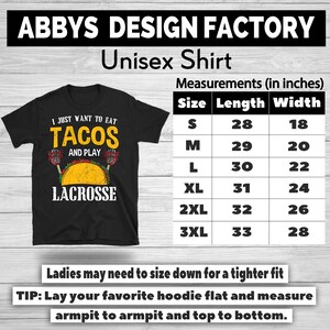 May include: Black unisex t-shirt with the text "I just want to eat tacos and play lacrosse." The shirt includes a graphic of a taco and lacrosse sticks. Measurements are provided in inches for various sizes.