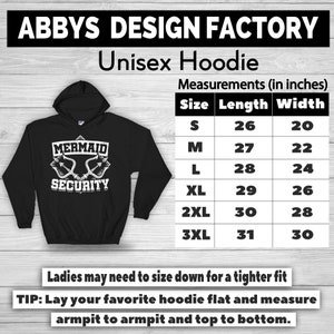 Puede incluir: Sudadera con capucha unisex negra con el texto blanco &laquo;MERMAID SECURITY&raquo;. La sudadera con capucha incluye una tabla de tallas con medidas en cent&iacute;metros. El texto &laquo;ABBYS DESIGN FACTORY&raquo; est&aacute; en la parte superior.