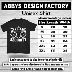 Puede incluir: Camiseta unisex negra con el texto blanco "MERMAID SECURITY". La tabla de tallas muestra las medidas en cm, desde la talla S (71cm de largo, 46cm de ancho) hasta la 3XL (84cm de largo, 71cm de ancho).