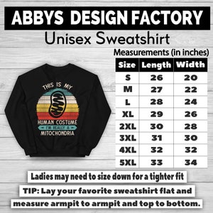 May include: Black unisex sweatshirt with a retro design. The graphic reads "THIS IS MY HUMAN COSTUME I'M REALLY A MITOCHONDRIA" with a mitochondria illustration. Measurements are provided in inches, with sizes ranging from S to 5XL.